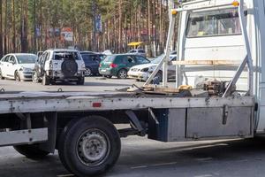 beaucoup de vieilles voitures prêtes à être recyclées. enlèvement de voiture par dépanneuse. la voiture s'apprête à être chargée sur une dépanneuse. de vieilles voitures accidentées dans un dépotoir attendent d'être détruites dans un parc de recyclage. photo