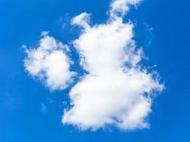 deux nuages moelleux dans un ciel bleu foncé en été photo