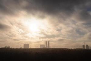 smog sur le parc de la ville et les maisons urbaines à l'horizon photo