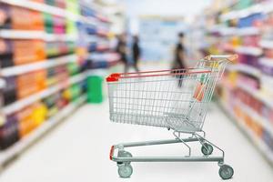 allée de supermarché flou fond défocalisé avec panier rouge vide photo