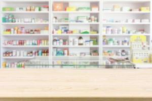 Table de comptoir de pharmacie de pharmacie avec fond abstrait flou avec des médicaments et des produits de santé sur des étagères photo