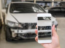 femme tenant un smartphone et prenant une photo d'un accident de voiture