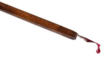 goutte d'encre rouge sur la pointe d'un stylo plume marron photo