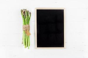 asperges vertes fraîches avec cadre de tableau noir photo