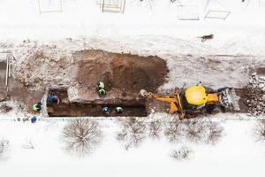 Vue ci-dessus des travailleurs de la route changeant de tuyau en hiver photo