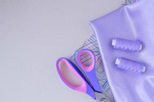 accessoires de couture pour travaux d'aiguille. bobines de fil et autres équipements de couleur violette qu'utilise un tailleur pour coudre. photo