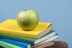 pomme sur le dessus d'une pile de livres, au dos des classes d'école. photo