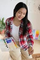 jeune fille peignant sur papier à la maison, cadre en bois, passe-temps et étude d'art à la maison. photo