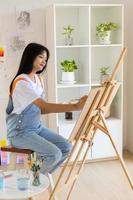 jeune fille peignant sur papier à la maison, cadre en bois, passe-temps et étude d'art à la maison. photo