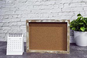 calendrier blanc de mai 2022 avec cadre en bois et plante en pot sur un bureau en bois. photo