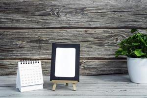 calendrier blanc de septembre 2022 sur un bureau en bois avec cadre en papier et plante en pot. Concept du nouvel an 2022. espace de copie. photo