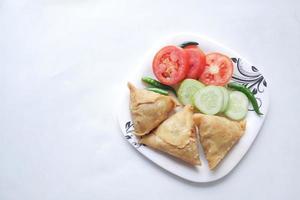 vue de dessus du samosa indien et de la tomate sur une assiette photo