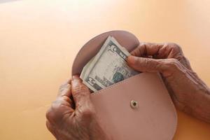 les femmes âgées économisent de l'argent dans le portefeuille photo