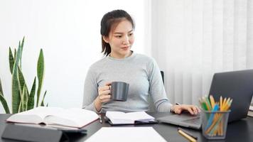 concept de travail de bureau une secrétaire féminine tenant une tasse de café faisant son travail de manière relaxante photo