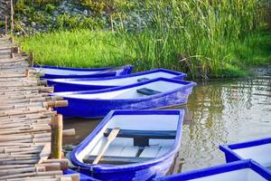 bateau en plastique sur le lac riverain et pont en bois photo