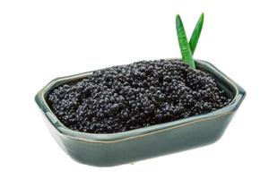 caviar noir dans un bol sur fond blanc photo