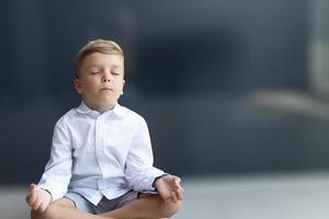 garçon zen méditant les yeux fermés. photo