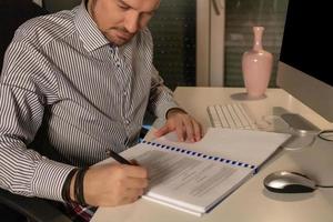 homme d'affaires finissant la paperasse tout en travaillant la nuit au bureau. photo