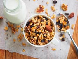 granola cuit maison avec amandes, noix, raisins secs et graines pour le petit déjeuner. photo