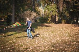 garçon heureux avec un cerf-volant qui tourne dans le parc. photo