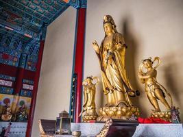 déesse dorée de la compassion ou statue de la déesse guanyin dans la salle du temple tianmen sur la montagne tianmen. le temple tianmen est au sommet de la montagne tianmen et point de repère de la ville de zhangjiajie en chine photo