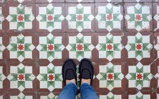 vue de dessus selfie des pieds dans des chaussures de baskets sur le fond de sol sans couture vintage avec espace de copie photo