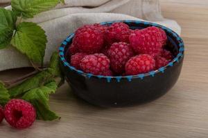 framboise fraîche dans un bol sur fond de bois photo