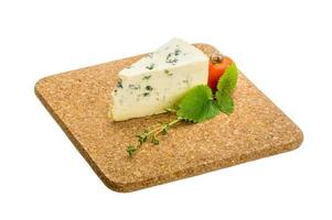 Fromage bleu sur planche de bois et fond blanc photo