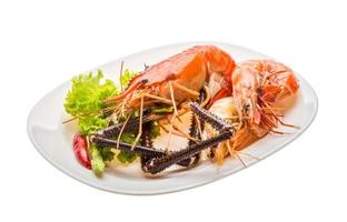 crevettes géantes d'eau douce et crevettes royales sur l'assiette et fond blanc photo