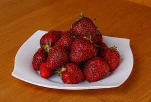 fraise sur la plaque et fond en bois photo