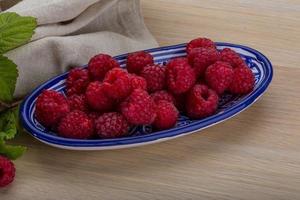 framboise fraîche dans un bol sur fond de bois photo