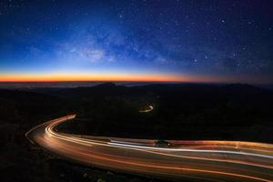 galaxie de la voie lactée avec étoiles et poussière spatiale dans l'univers et éclairage sur la route avant le matin à doi inthanon chiang mai, thaïlande photo