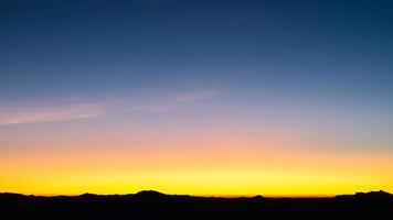 beau ciel nuageux lumineux avec lumière pour le fond de la religion du ciel. le paysage nuageux du lever et du crépuscule ou du coucher du soleil est orange et bleu dans la nature estivale. photo