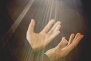 prière pliée à la main à dieu dans l'obscurité dans le concept d'église pour la foi, la spiritualité et la religion, femme personne priant sur la sainte bible le matin. main de femme catholique chrétienne avec culte sur fond noir. photo