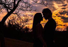 silhouette de couple romantique amoureux, homme et femme dans le ciel coucher de soleil. romantique des relations entre couple amour dans le jardin photo