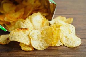 croustilles dans un sac ouvert, délicieux assaisonnement pour barbecue épicé pour les frites, collation frite en tranches fines restauration rapide dans un sac ouvert. photo