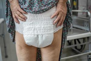 Patiente asiatique âgée ou âgée de vieille dame portant une couche d'incontinence dans une salle d'hôpital de soins infirmiers, concept médical solide et sain. photo