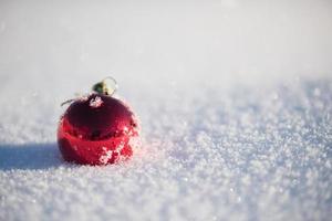 boule de noël rouge dans la neige fraîche photo