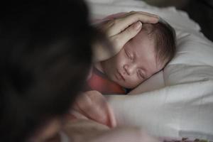 bébé nouveau-né qui dort et qui sourit dans ses rêves photo