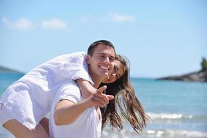 heureux jeune couple s'amuser sur la plage photo