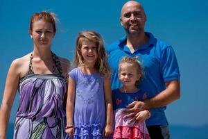 portrait de jeune famille heureuse avec des filles au bord de la mer photo