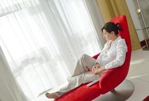 heureuse jeune femme se détendre à la maison sur un canapé photo