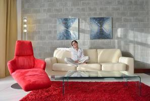heureuse jeune femme se détendre à la maison sur un canapé photo