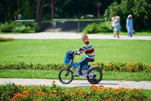 garçon heureux apprenant à monter son premier vélo photo