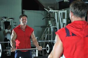 homme fort s'entraîner dans la salle de gym photo