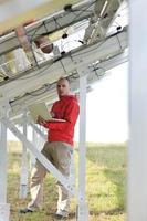 ingénieur utilisant un ordinateur portable sur le terrain de l'usine de panneaux solaires photo