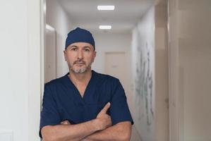 portrait d'un médecin de sexe masculin mature dans un couloir d'hôpital moderne et animé. photo