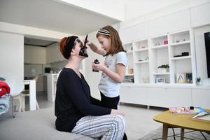 mère et fille à la maison faisant un traitement de beauté au masque facial photo