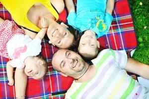 heureux jeune couple avec leurs enfants s'amuser au parc photo