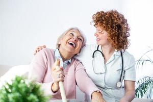 relation amicale entre un soignant souriant en uniforme et une femme âgée heureuse. jeune infirmière de soutien regardant une femme âgée. jeune soignant adorable et pupille heureuse photo